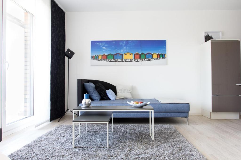 a living room with a blue couch and a table at Refugium 1 in Emsdetten