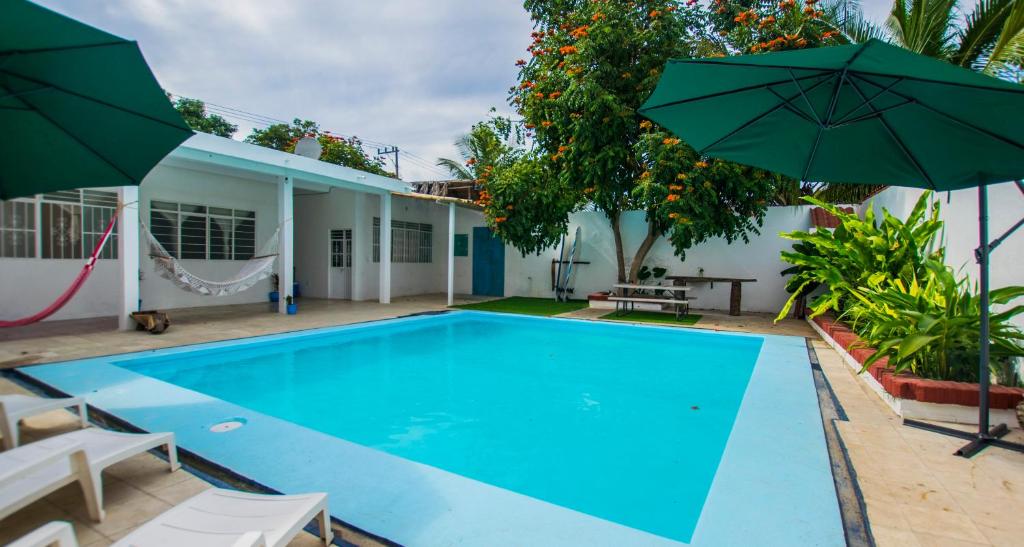 a swimming pool with two umbrellas next to a house at Casa Pancho Playa in San Francisco