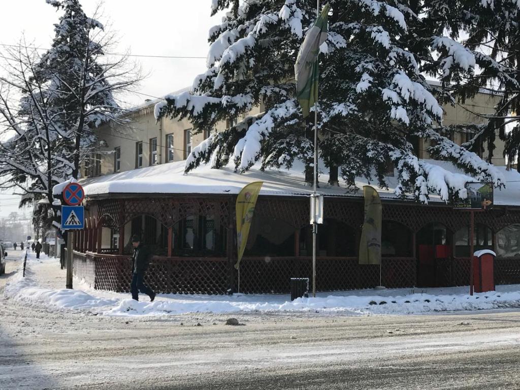 osoba stojąca w śniegu przed budynkiem w obiekcie Pensiunea Mioritza w mieście Horezu