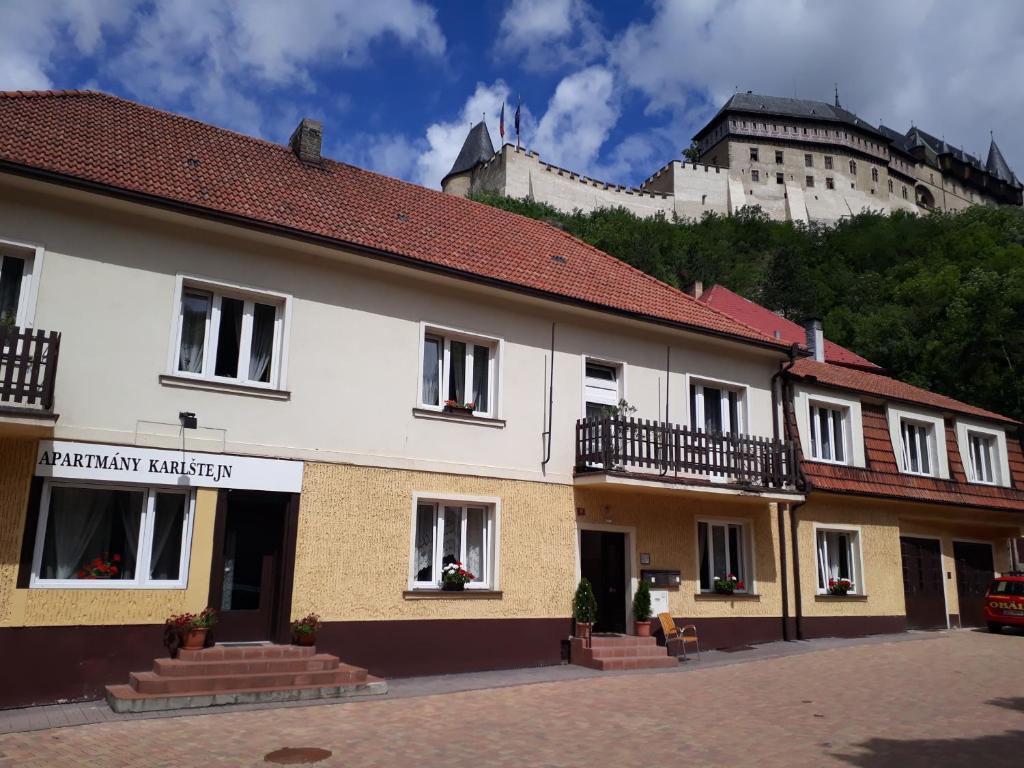 ein Gebäude mit einem Schloss im Hintergrund in der Unterkunft Apartmány Karlštejn in Karlštejn