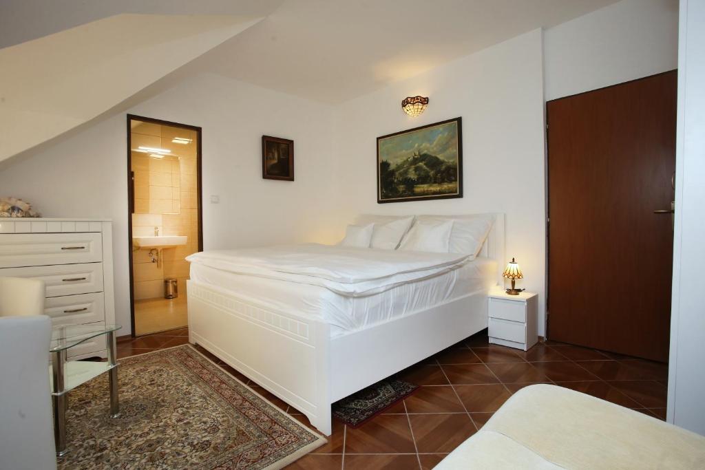 ブフロヴィツェにあるRestaurant penzion u Buchlovskeho zamkuのベッドルーム1室(白い大型ベッド1台付)