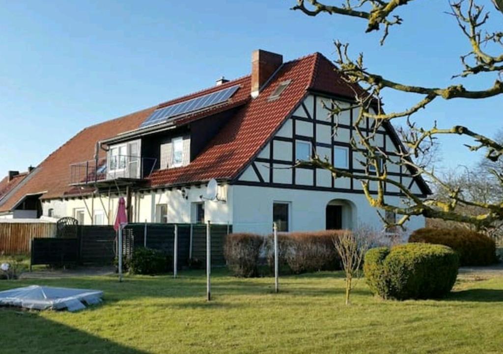 une grande maison blanche avec un toit rouge dans l'établissement Fewo am Saalerbodden, à Bartelshagen