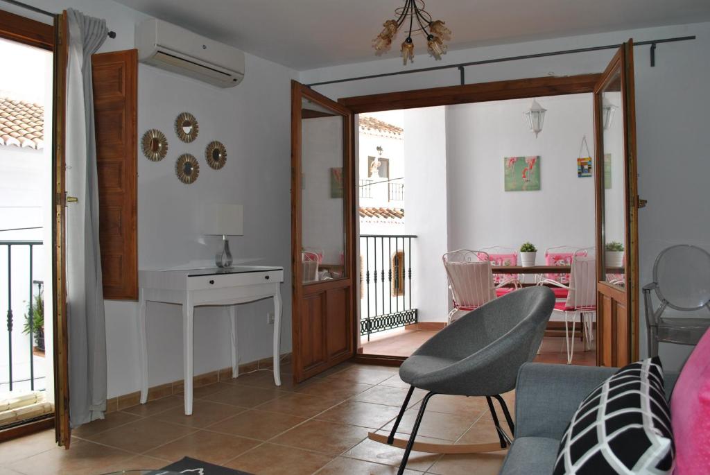 a living room with a door open to a dining room at Casa La Plaza in Frigiliana