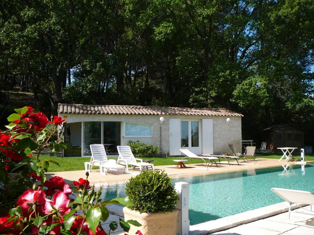 a house with a swimming pool with chairs and a house at un lit en provence in Éguilles