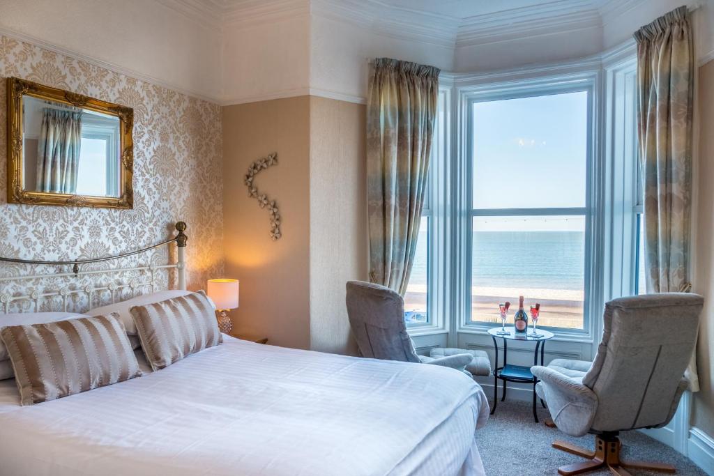 a bedroom with a bed and a view of the ocean at The Grafton Guest House in Llandudno