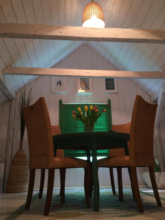 een tafel met twee stoelen en een vaas met bloemen erop bij Pokoje Sweet Home in Stegna