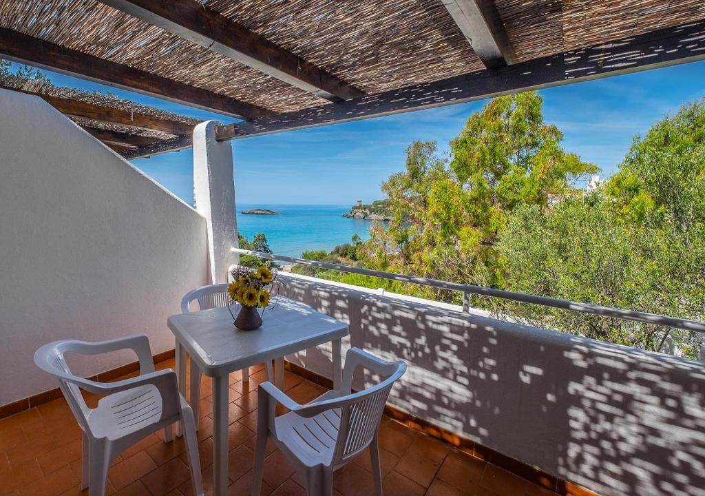 un tavolo e sedie su un balcone con vista sull'oceano di Macinelle a Marina di Camerota