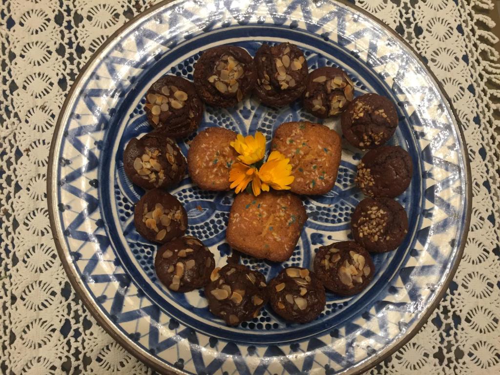 a blue and white plate with cookies and a yellow flower at Hotel Svizzera in Arma di Taggia
