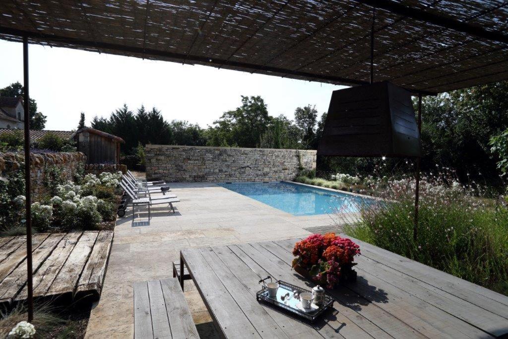 um quintal com uma piscina e um deque de madeira em La Maison Du Meunier em Loze