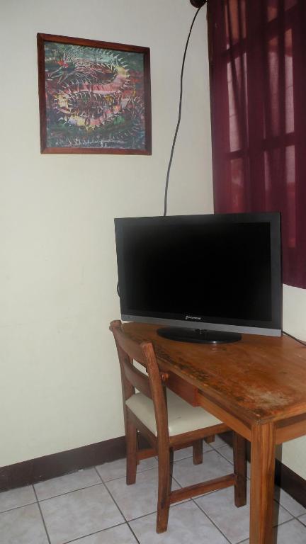 a wooden table with a television on top of it at AC Room 2 Persons Hospedaje Don Wilfredo in San Juan del Sur