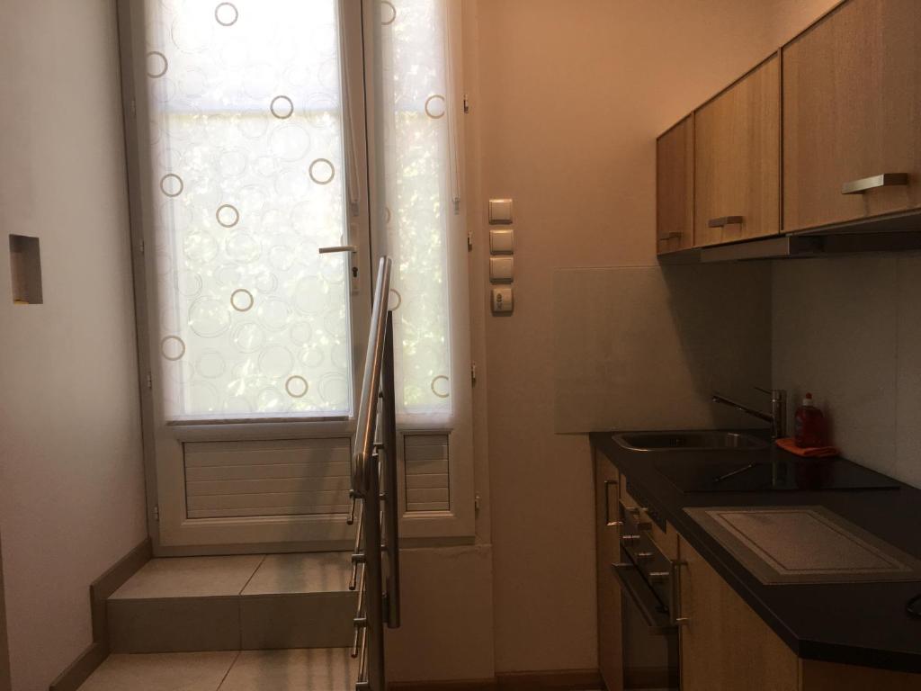 una pequeña cocina con ventana y fregadero en Sainte Maxime Studio 2, en Sainte-Maxime
