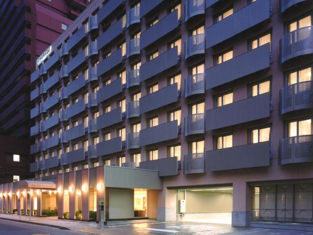 a tall blue building with lights in front of it at Hotel Hokke Club Hiroshima in Hiroshima