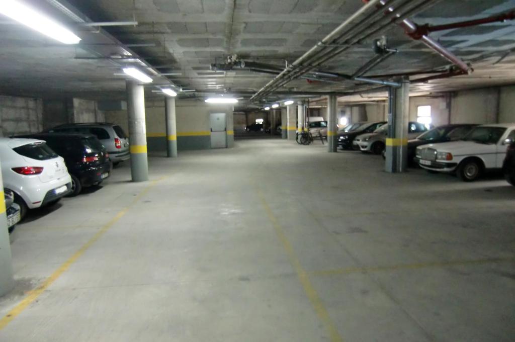 a parking lot with cars parked in a parking garage at The Surf Studio - Ericeira in Ericeira