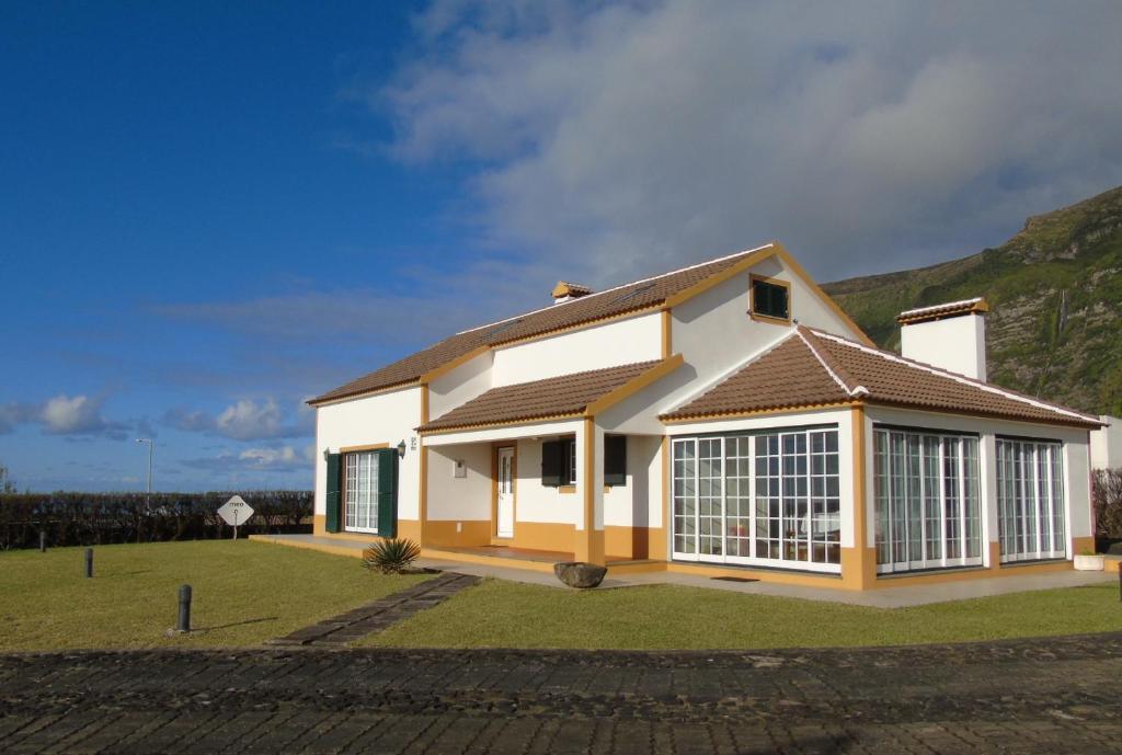 a white house with a brown roof at Casa dos Salgueiros in Faja Grande