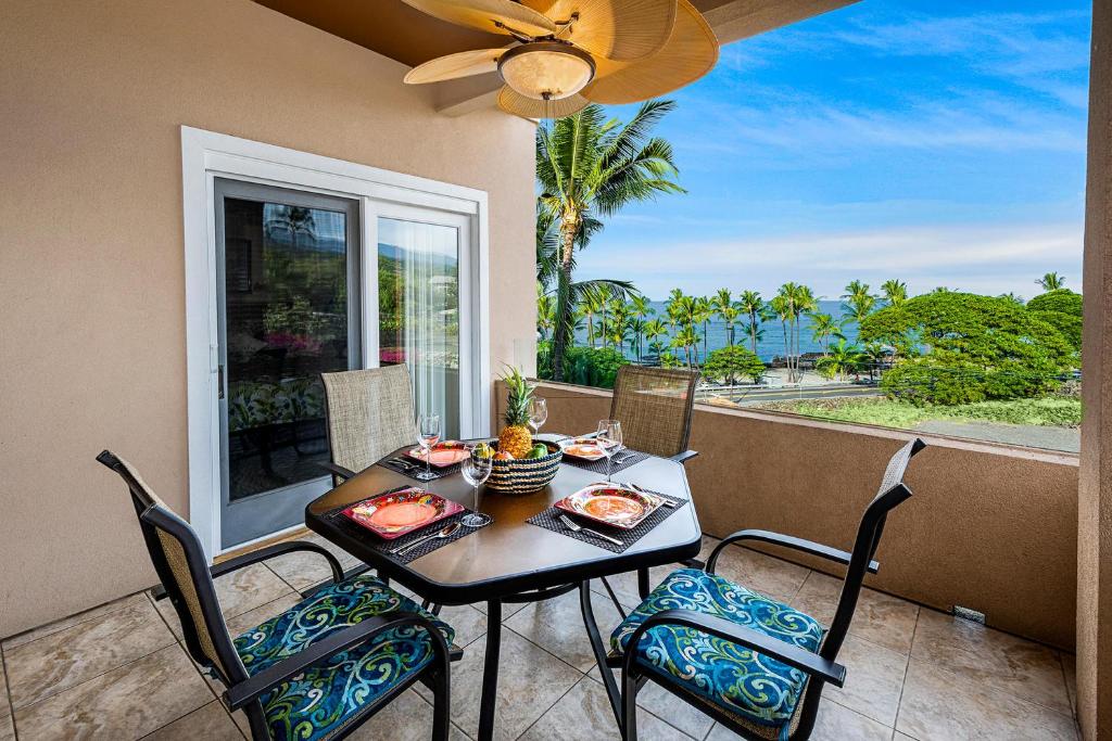 stół i krzesła na balkonie z widokiem na ocean w obiekcie Beach Villas Kahaluu on Kona Coast w mieście Kailua-Kona