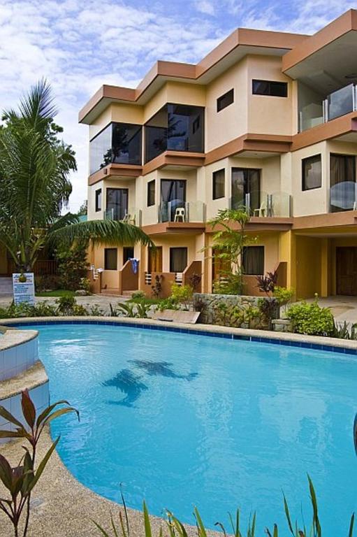 a house with a large swimming pool in front of it at Lost Horizon Beach Dive Resort in Panglao Island