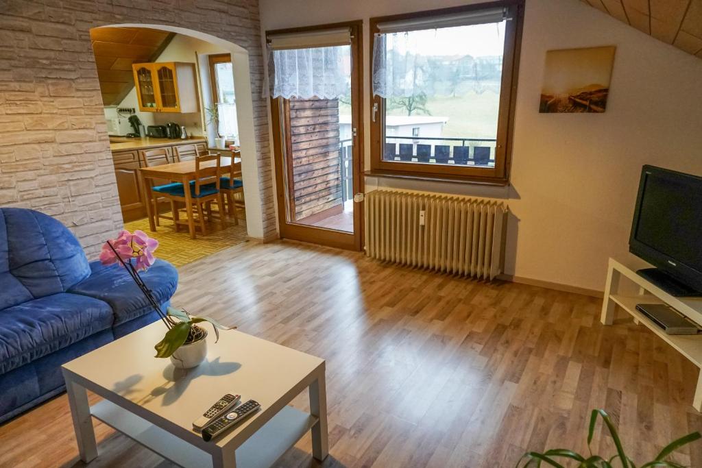 a living room with a blue couch and a table at Monteurzimmer Hochsal in Laufenburg