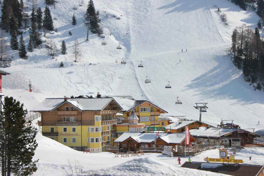 a ski lodge in the snow with a ski slope at Hotel Breitlehenalm in Obertauern