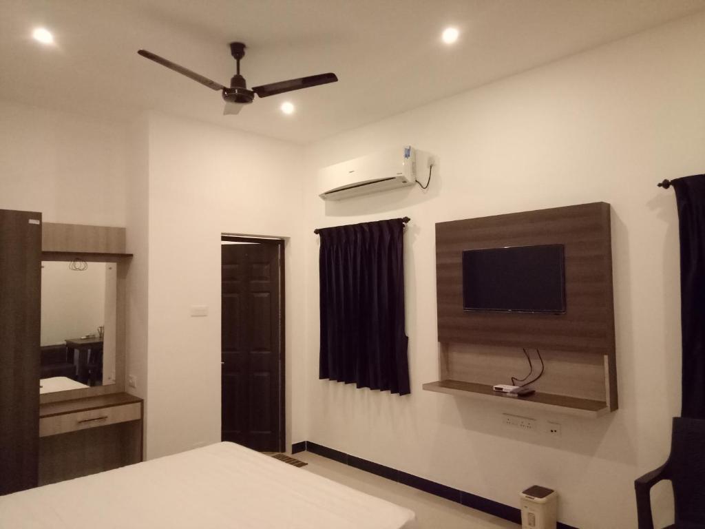 a bedroom with a bed and a flat screen tv at ComfortWings in Coimbatore