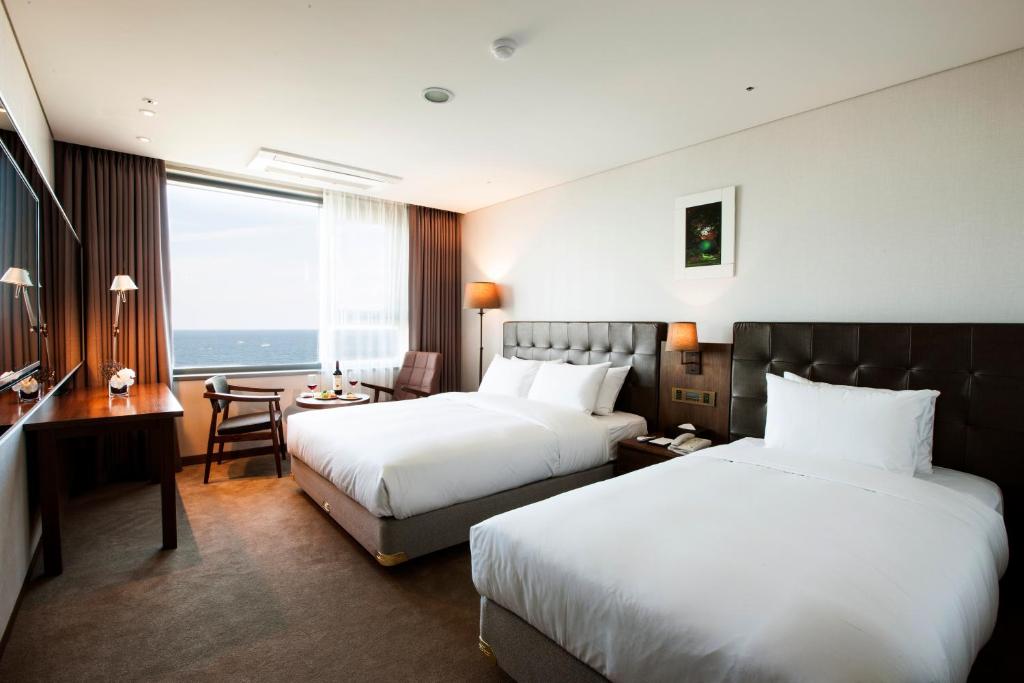Postel nebo postele na pokoji v ubytování Grabel Hotel Jeju