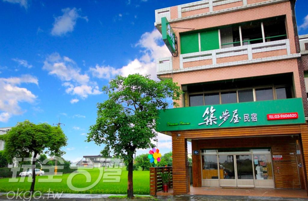 un edificio con una señal verde en el costado. en Dream House B&B en Luodong