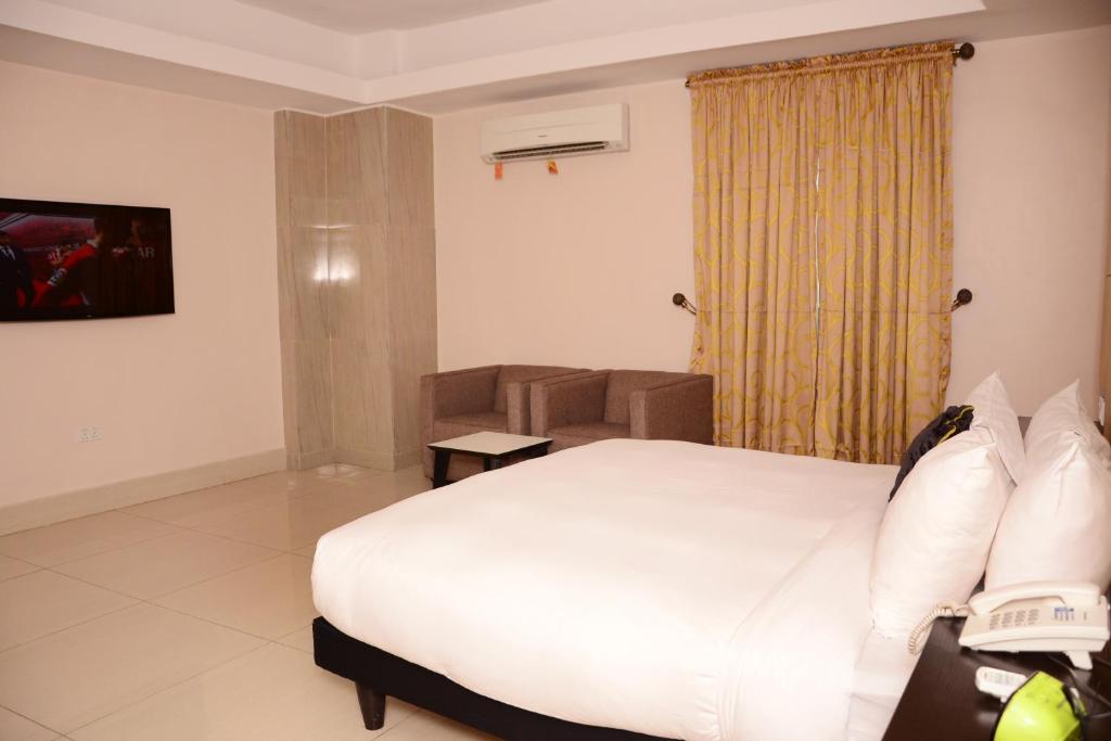 a bedroom with a bed and a chair in a room at BWC Hotel in Lagos