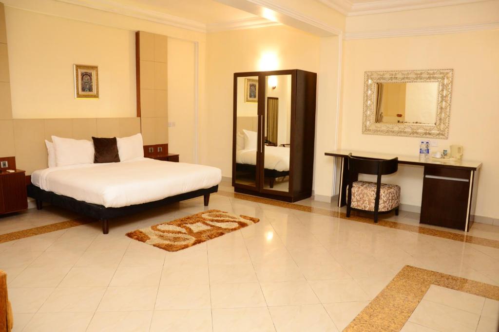 a bedroom with a bed and a mirror at BWC Hotel in Lagos
