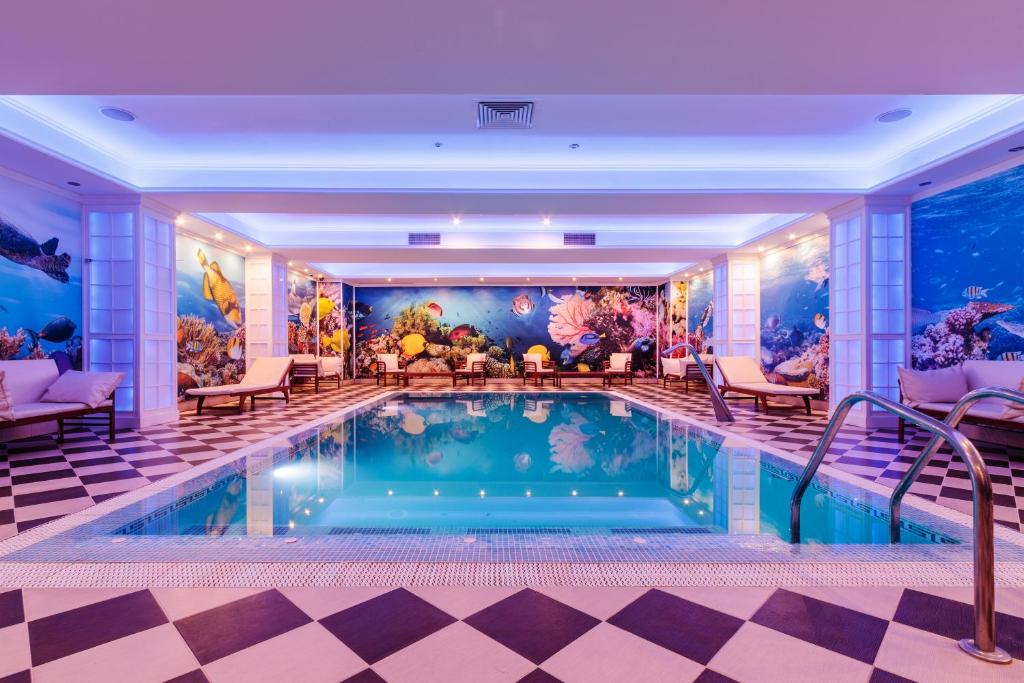 a swimming pool in a hotel room with a mural at Grand Hotel Sofianu in Râmnicu Vâlcea
