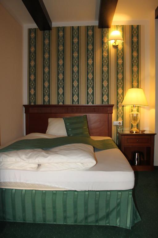 una camera da letto con un letto con una coperta verde e bianca di Penzion U Karla IV. a Kadaň