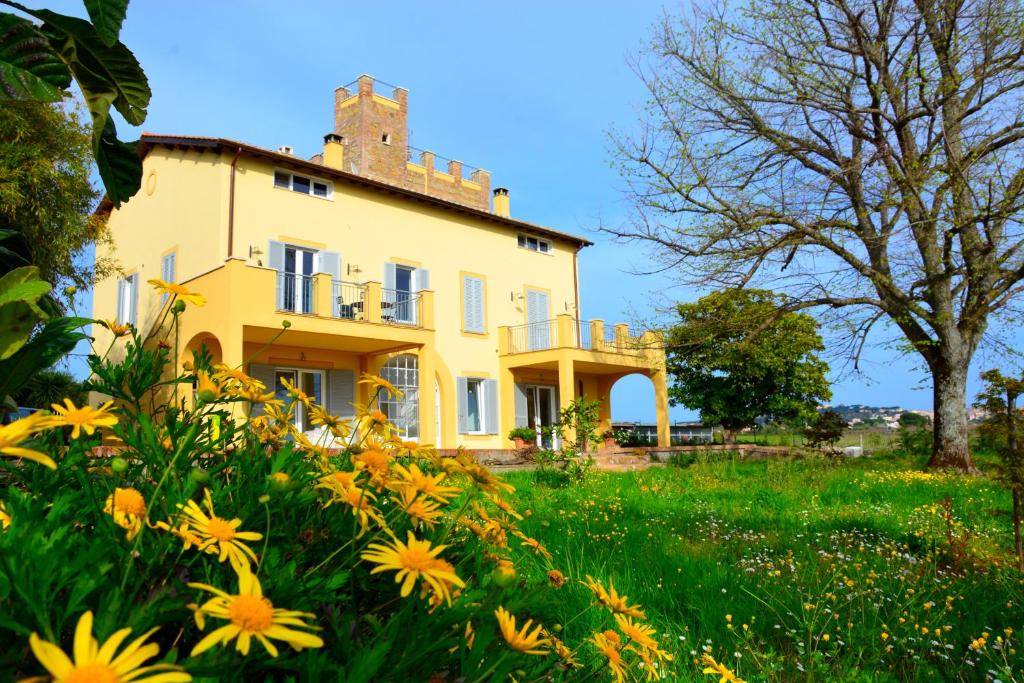 een huis in een veld met gele bloemen bij Casale Del Gelso in Genzano di Roma