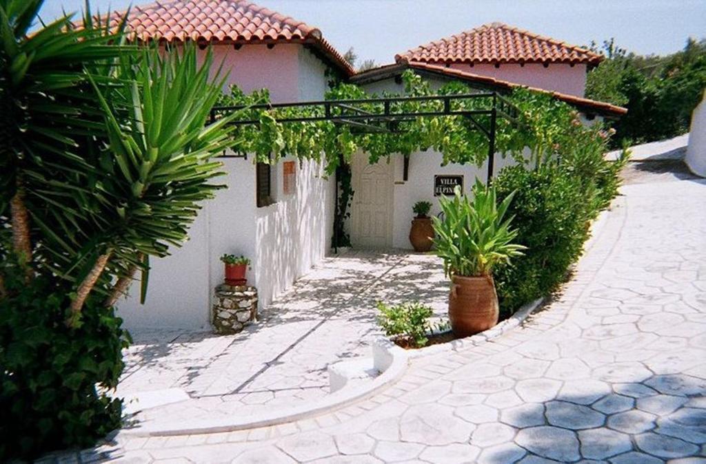 une maison blanche avec des plantes devant elle dans l'établissement Villa Elpiniki, à Troulos