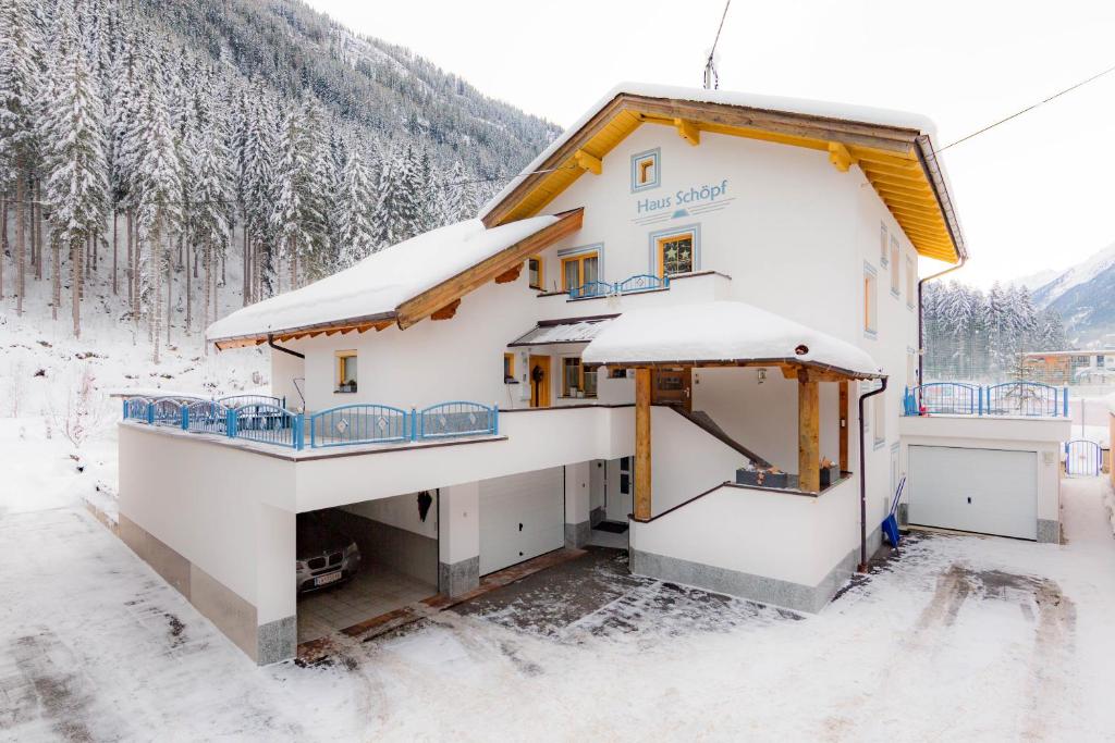 a house covered in snow in a forest at Haus Schöpf in Kappl