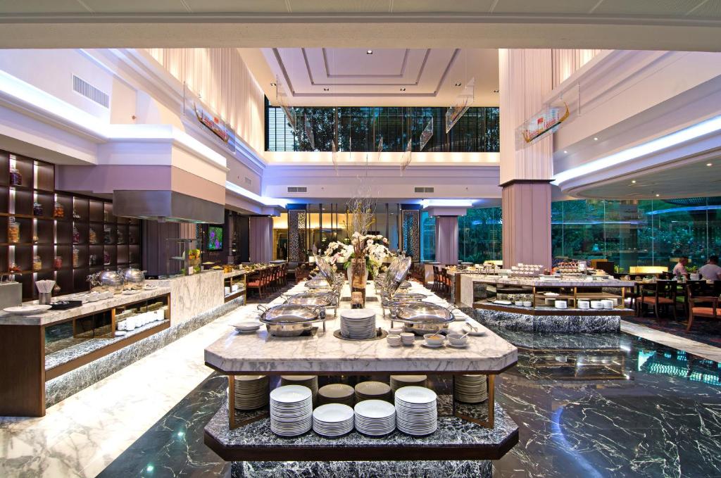 A bright buffet dining room centered on a long marble island of prepared dishes.