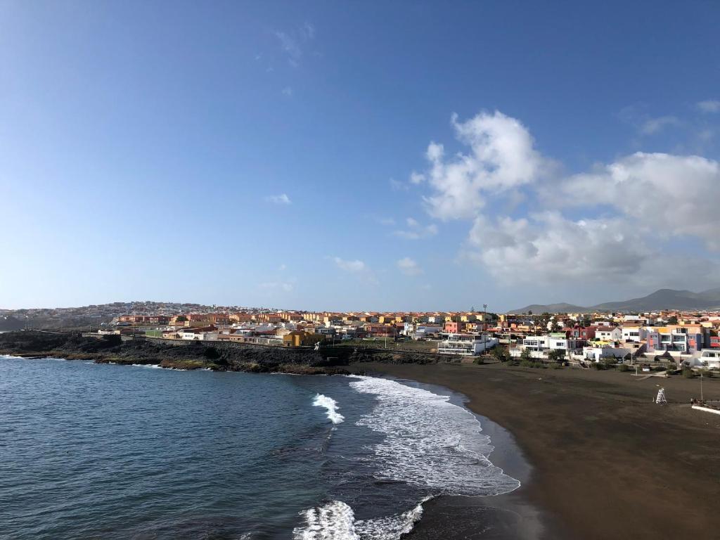 uma vista para uma praia com edifícios e o oceano em Apartamento en primera línea playa em La Garita