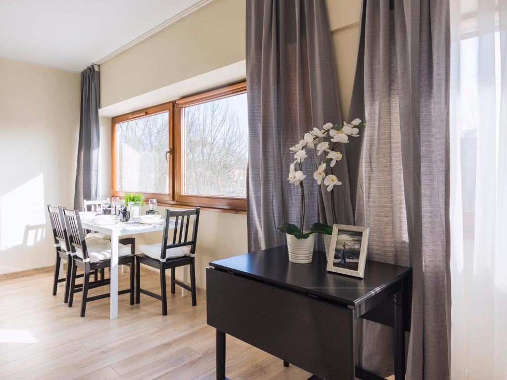 a dining room with a table and chairs and a window at VacationClub - Sand Hotel Apartment 308 in Kołobrzeg