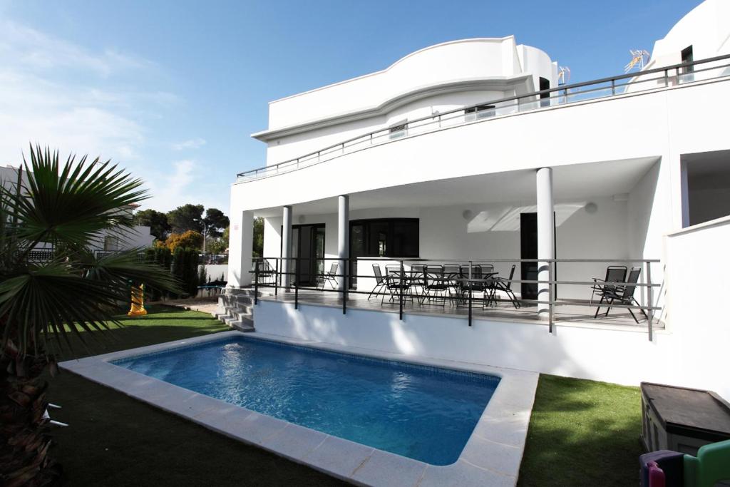 uma villa com piscina em frente a uma casa em Can Pastilla II em Can Pastilla