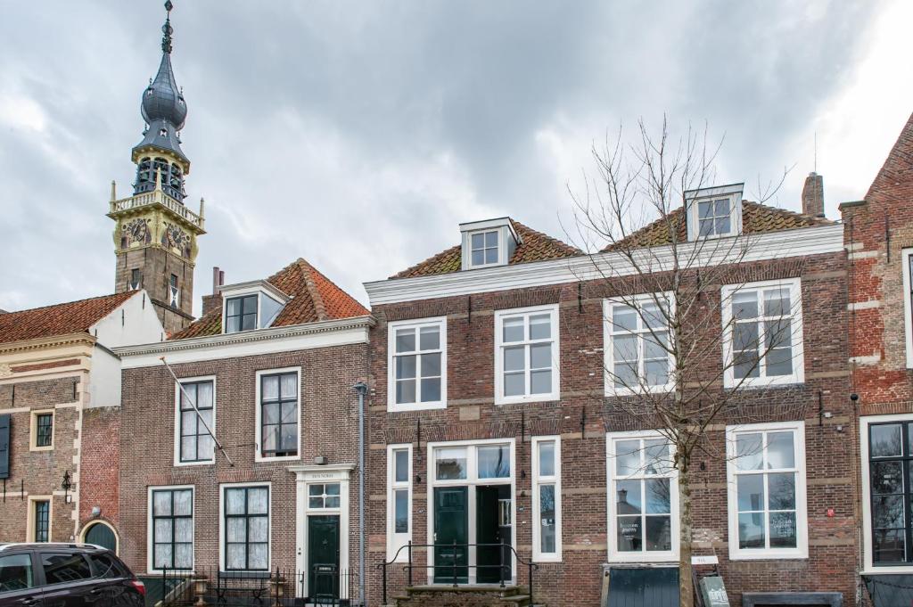 a large brick building with a clock tower at B&B bINNengewoon rooms with a view in Veere