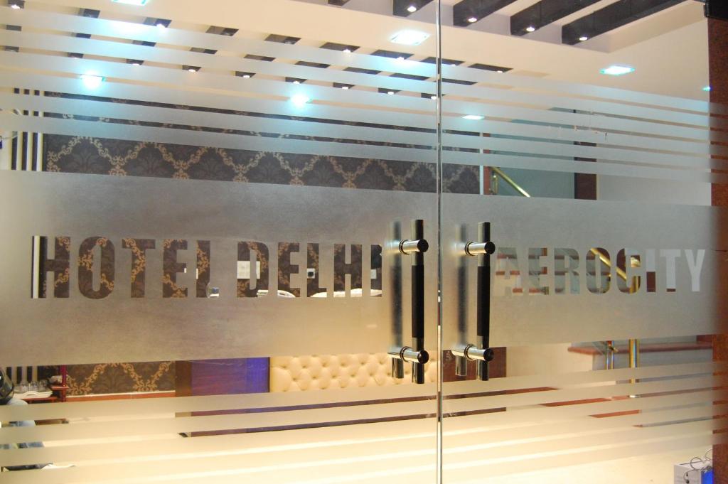 um quarto com uma porta de vidro com as palavras quarto de hotel em Hotel Delhi Aerocity, NH 8 em Nova Deli
