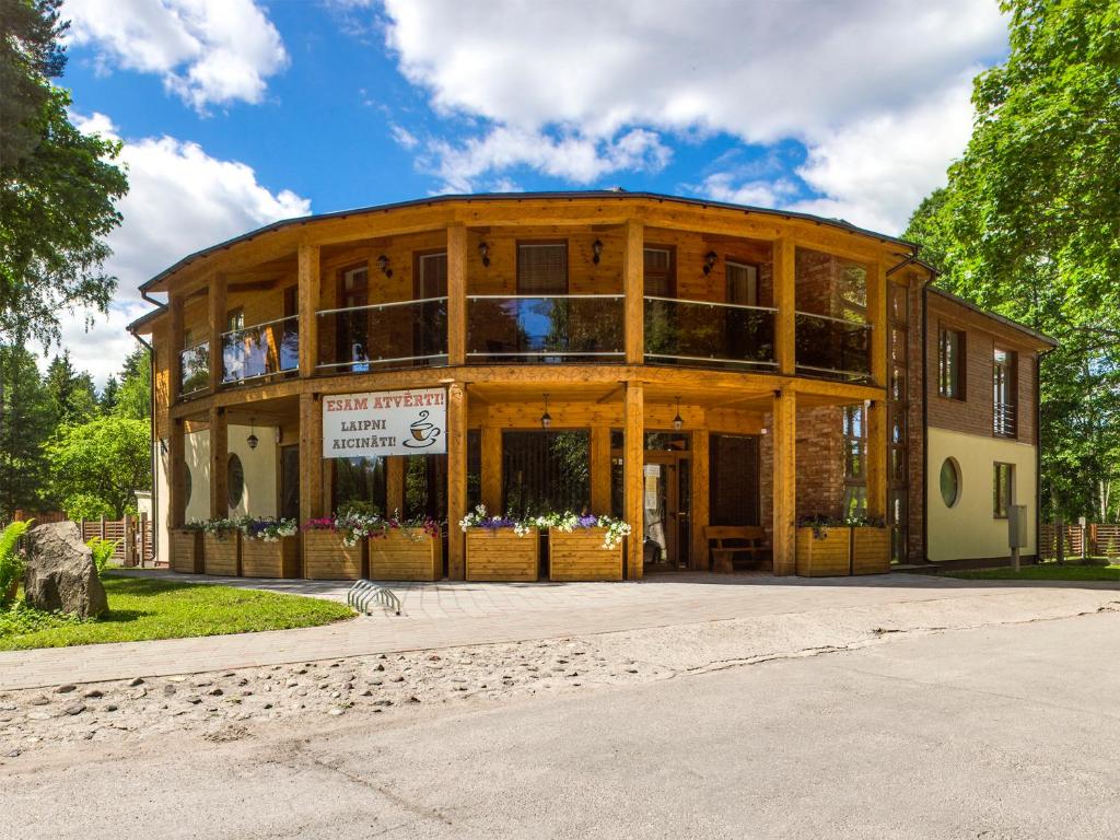 duży drewniany budynek z znakiem przed nim w obiekcie KEMERI Hotel in National Park - FREE PARKING w Jurmale