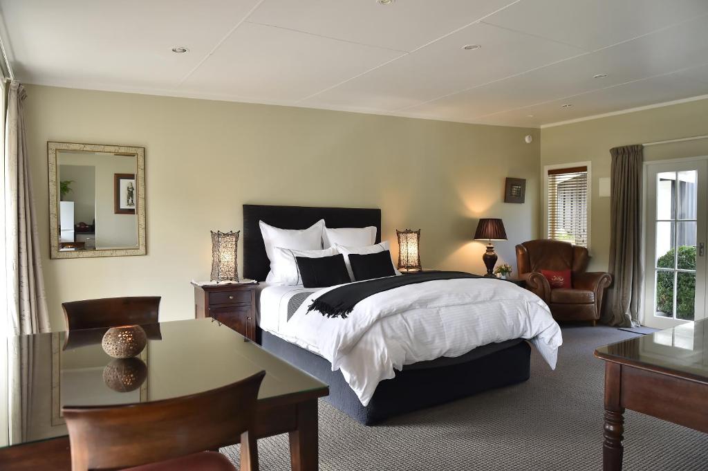 a bedroom with a large bed and a table and chairs at Bradleys Garden Bed and Breakfast in Taumarunui