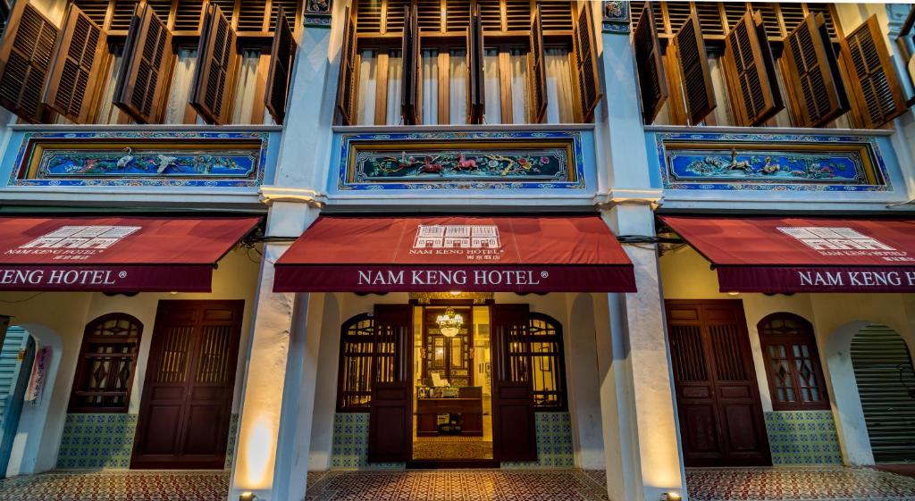 a building with red awnings on the front of it at Nam Keng Hotel Penang in George Town