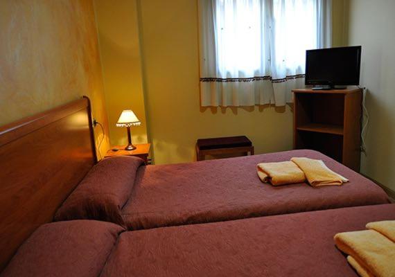 Hostal Puerta del Valle في بلد الوليد: غرفة نوم عليها سرير وفوط