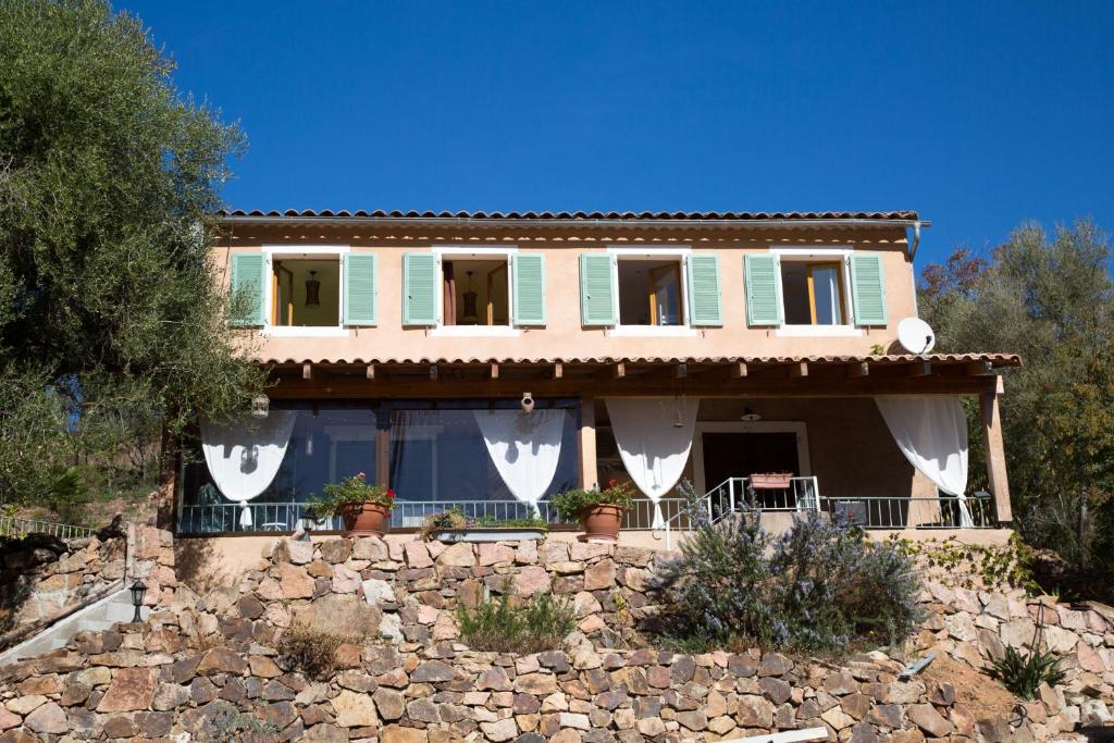 a house with a stone wall in front of it at Appartements A Merendella in Serriera