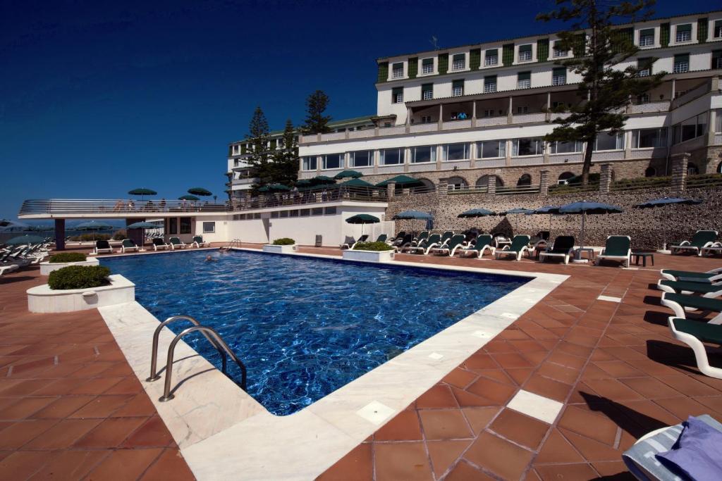 a swimming pool in front of a hotel at Vila Gale Ericeira in Ericeira