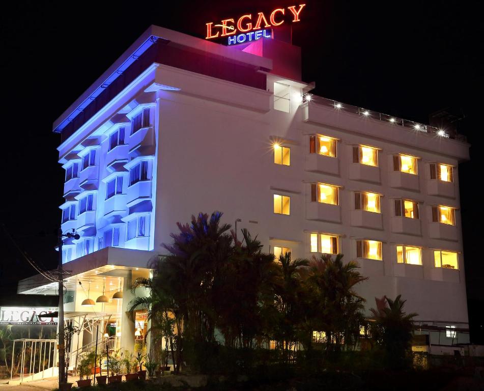 a hotel with a neon sign on top of it at Cochin Legacy in Cochin