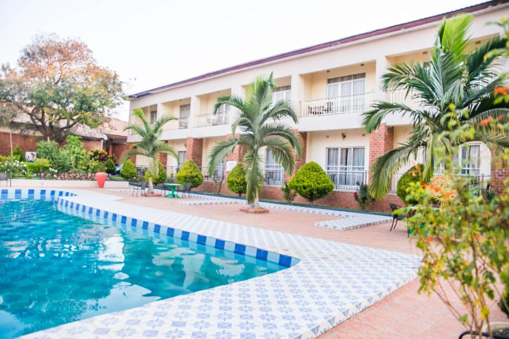 um hotel com piscina em frente a um edifício em Chamba Valley Exotic Hotel em Lusaka