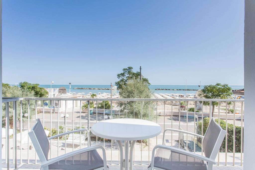 un balcon avec une table et des chaises et la plage dans l'établissement Hotel Delle Nazioni - Valentini Family Village, à Bellaria-Igea Marina
