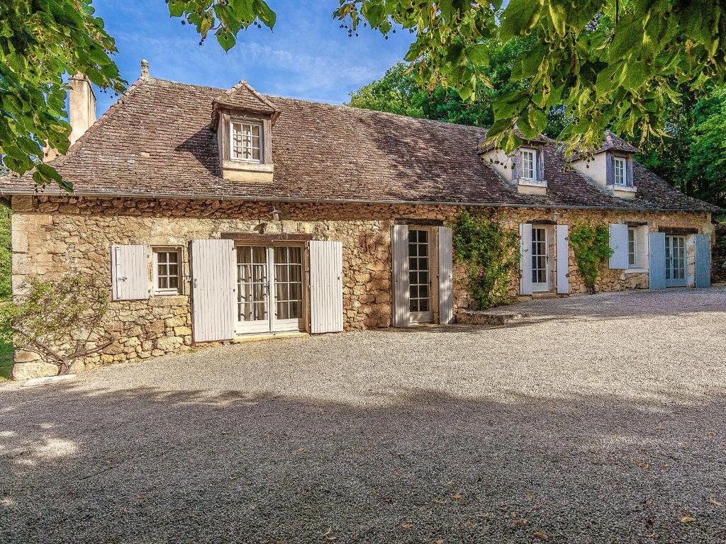 a stone house with a driveway in front of it at Sprawling Mansion in Aquitaine with Swimming Pool in Campsegret