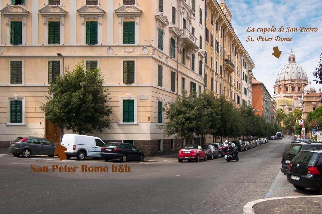 una strada cittadina con auto parcheggiate accanto a un edificio di San Peter Rome B&B a Roma