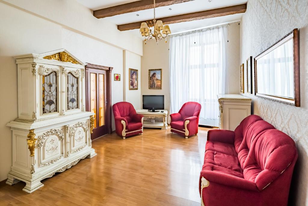 un soggiorno con sedie rosse e camino di 2 Virmens'ka Apartment a Lviv